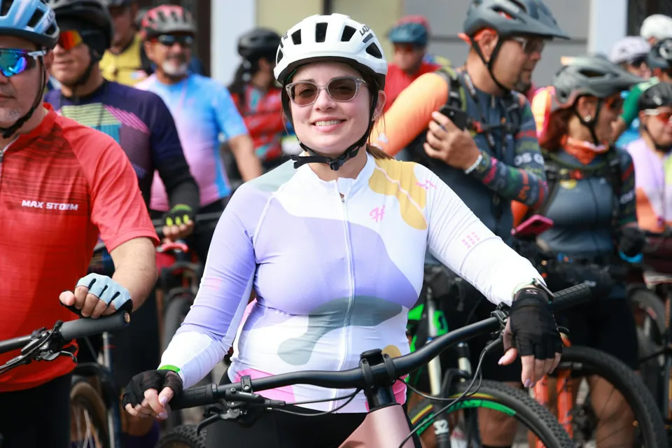 eine Person mit Helm, die ein Fahrrad hält