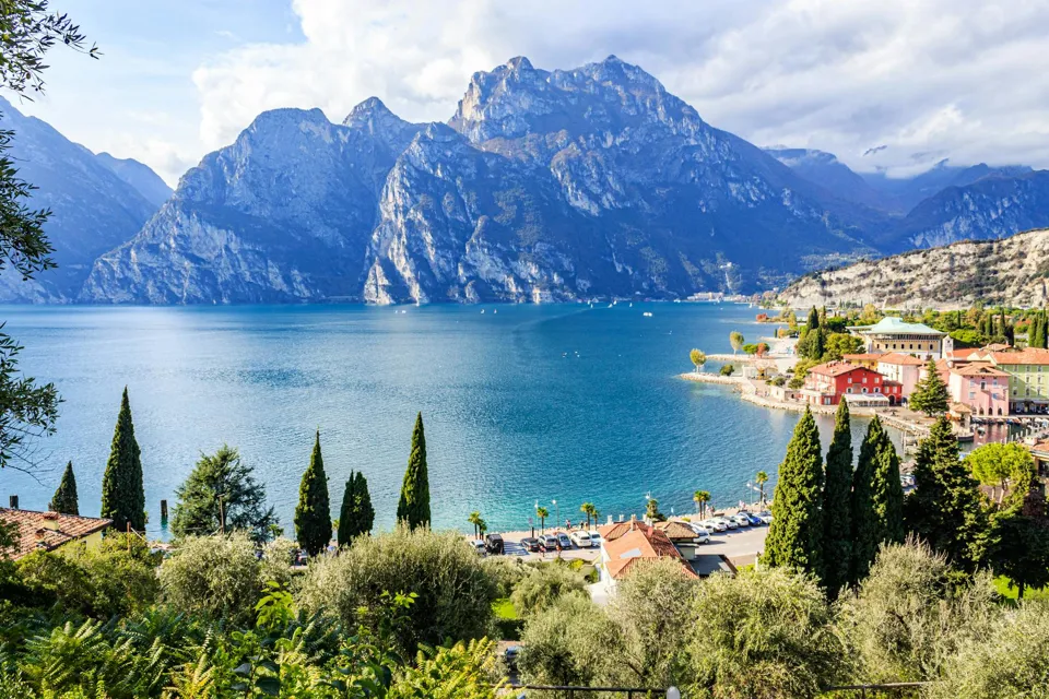 ein Gewässer mit Bäumen und Bergen im Hintergrund