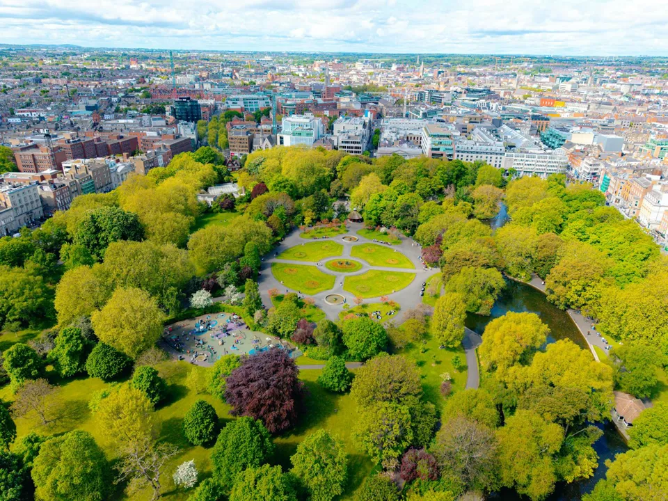 ein Park mit Robinienbäumen und Gebäuden