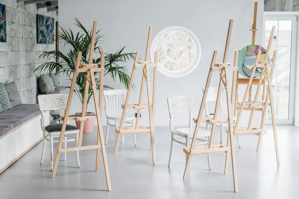 eine Gruppe von Stühlen und Staffeleien in einem Raum