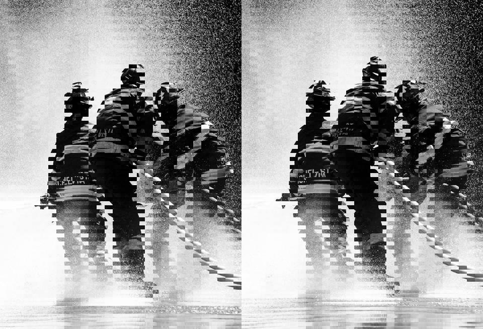 eine Gruppe von Feuerwehrleuten, die einen Schlauch benutzen