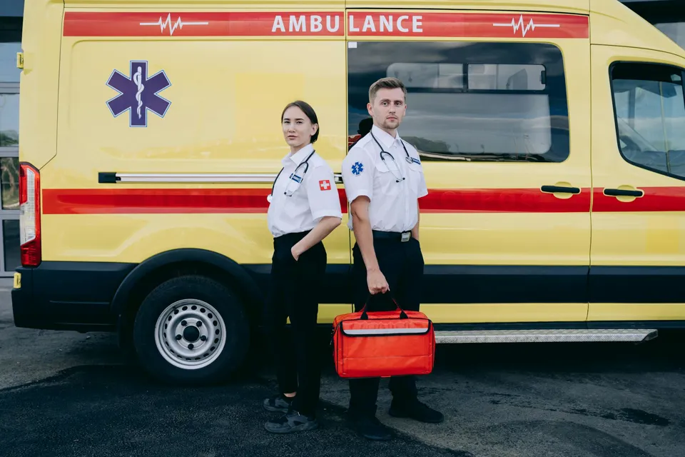 Ein paar Personen in Uniform stehen vor einem gelb-weißen Van.
