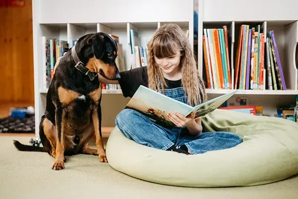 Kind liest ein Buch mit dem Lesehund aus Texing