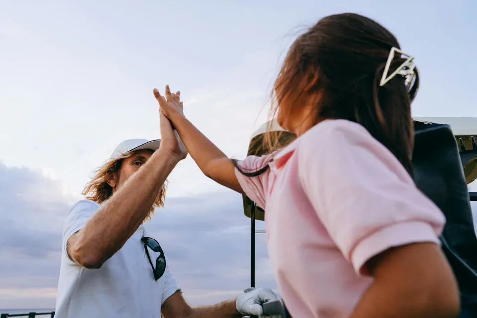 Eine Person und ein Kind geben sich ein High-Five.