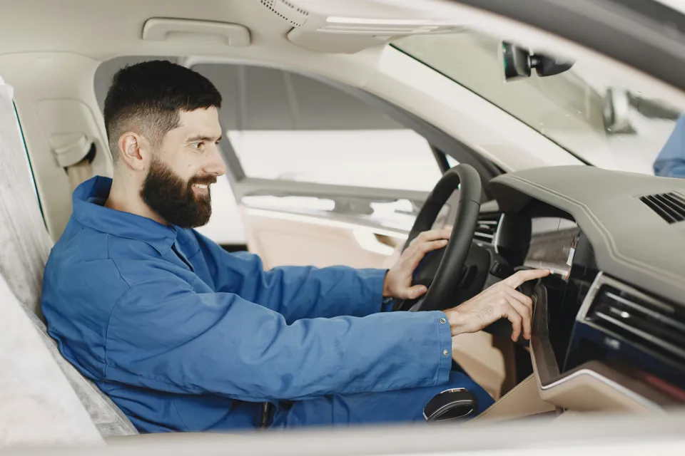 eine Person in einer blauen Jacke fährt ein Auto