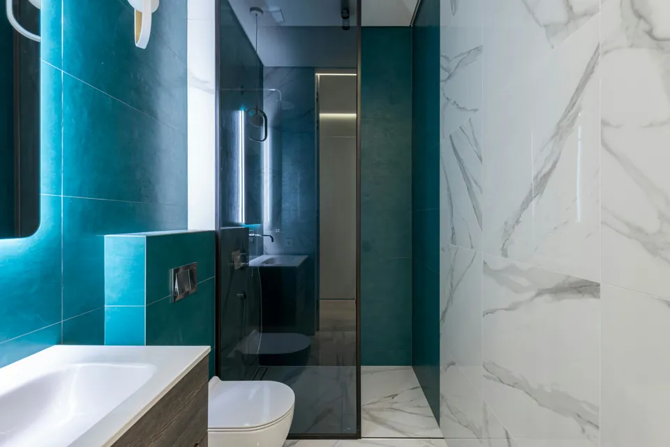 Ein Badezimmer mit einer Glasdusche und einer Toilette.