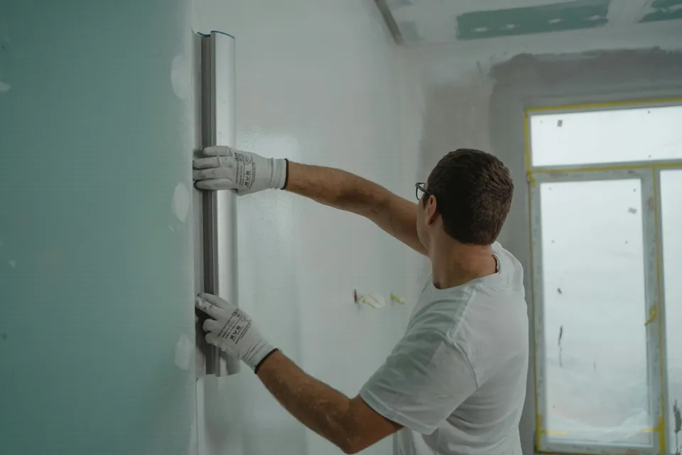 eine Person, die eine Wand streicht