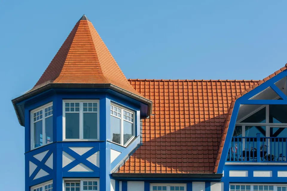 ein blau-weißes Gebäude mit rotem Dach