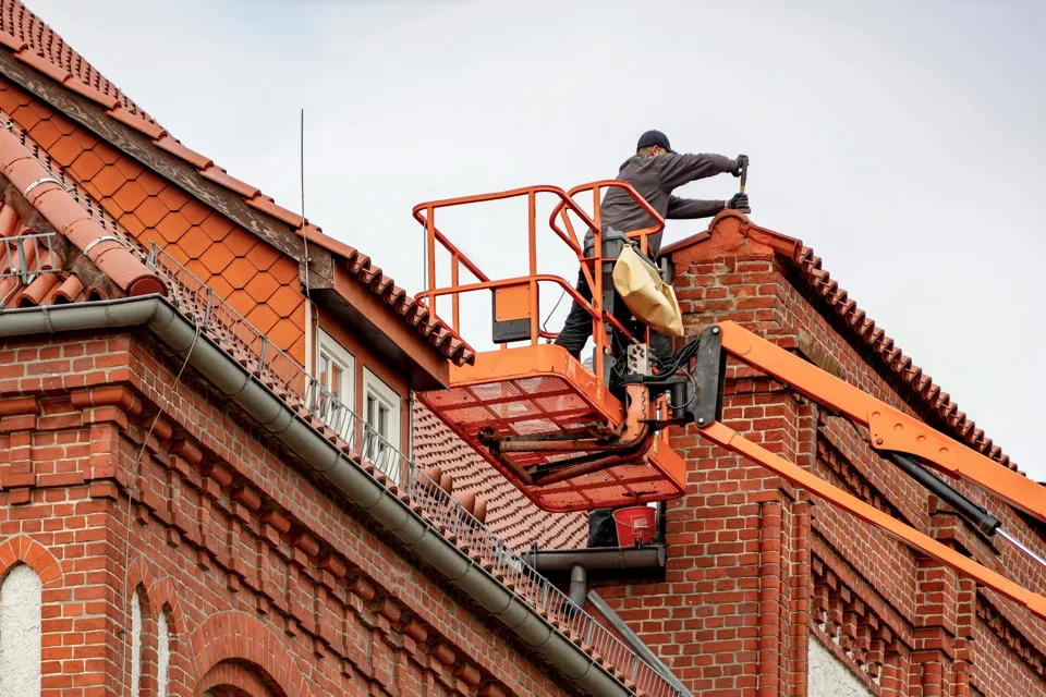 eine Person auf einem Aufzug in einem Backsteingebäude