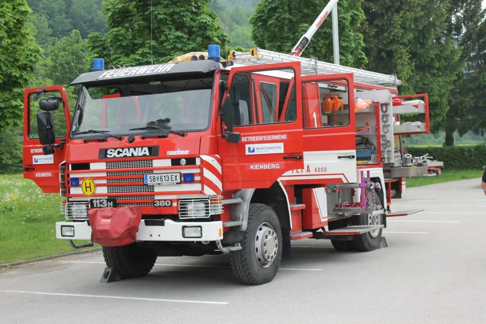 Ein rotes Feuerwehrauto, das auf einem Parkplatz geparkt ist.
