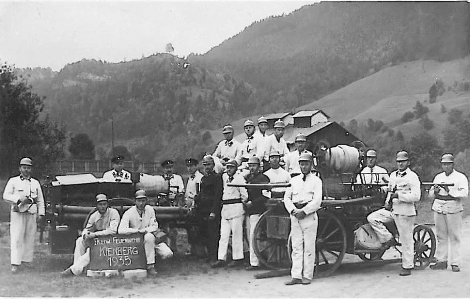 eine Gruppe von Männern in Uniform, die neben einer Kutsche stehen