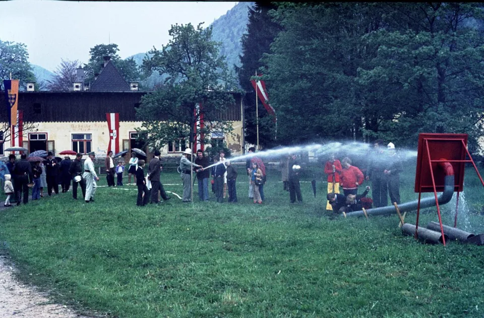 Eine Gruppe von Menschen sprüht Wasser auf den Rasen.