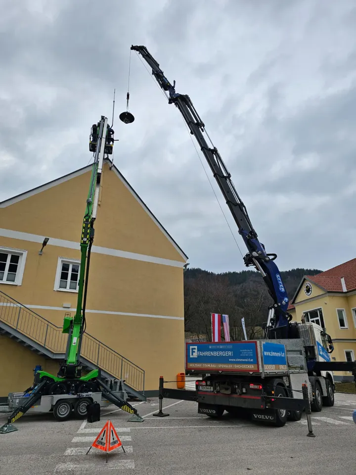 Ein Kran hebt ein Licht auf einen Lastwagen.