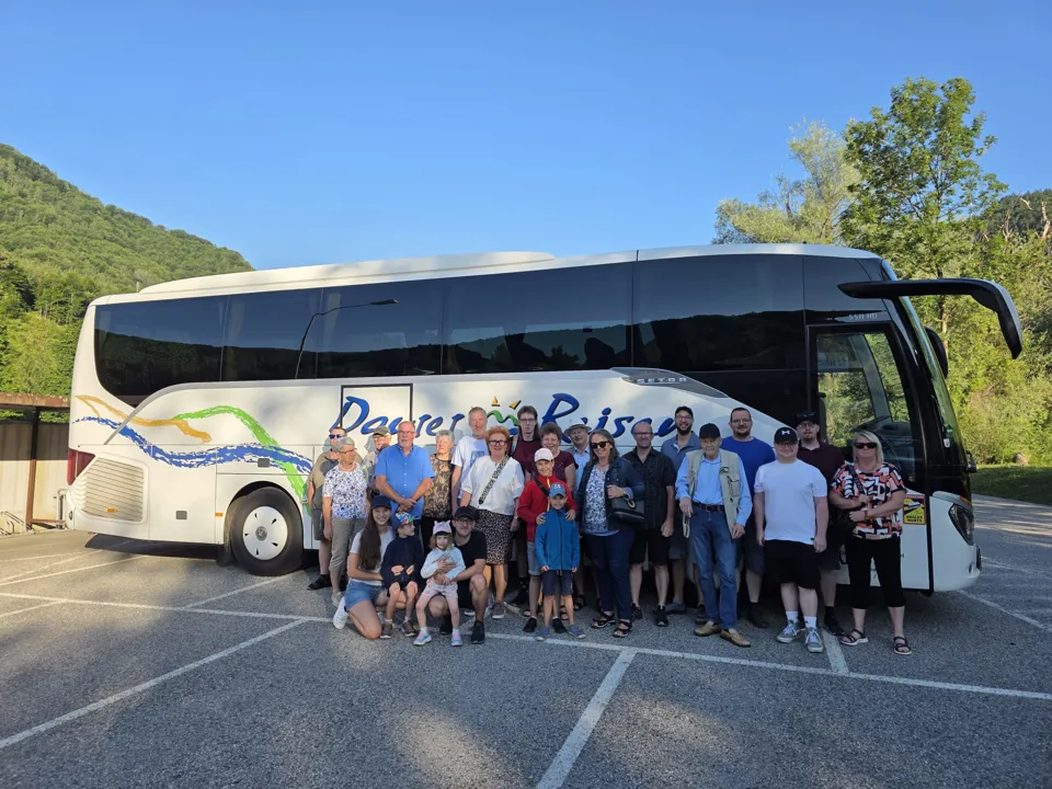 Eine Gruppe von Menschen steht vor einem Bus.