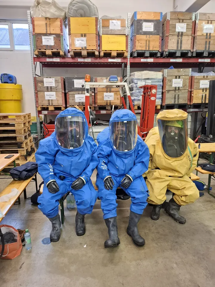 eine Gruppe von Menschen, die Schutzanzüge und Gesichtsmasken tragen