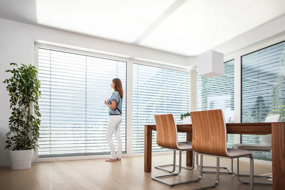 eine Person, die in einem Raum mit einem Tisch und Stühlen steht