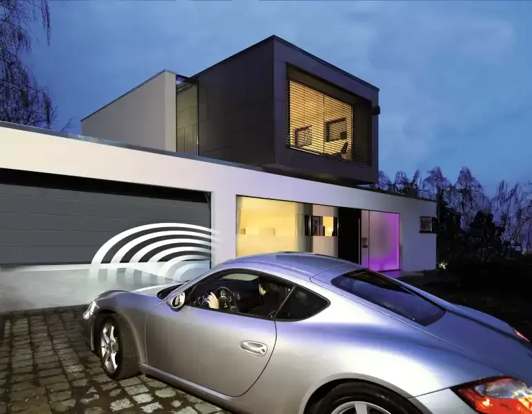 Ein silbernes Sportauto, das vor einem Haus geparkt ist.