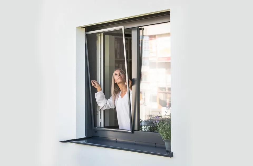 eine Person, die aus einem Fenster schaut