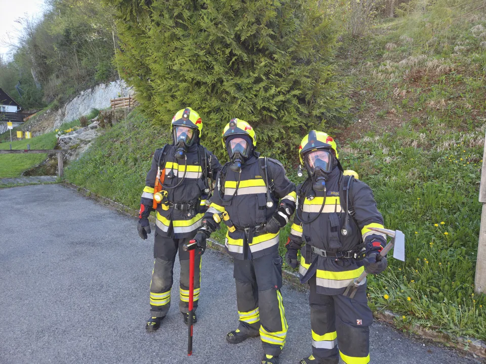 eine Gruppe von Feuerwehrleuten, die auf einer Straße stehen