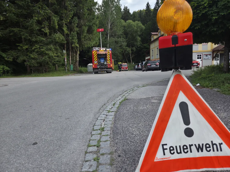 eine Straße mit einem Schild und einem Feuerwehrauto