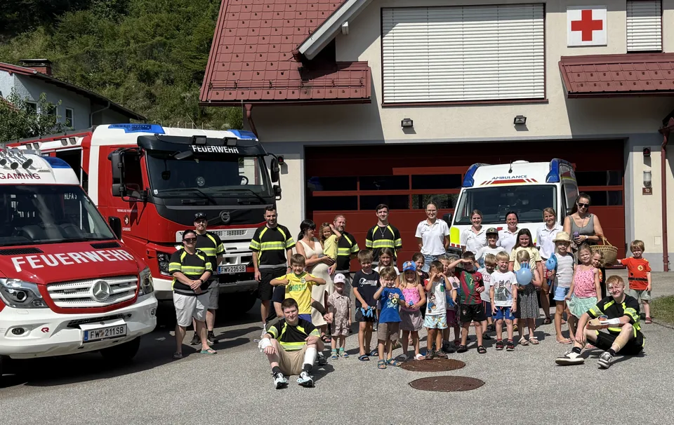 Eine Gruppe von Menschen posiert für ein Foto vor einem Feuerwehrauto.