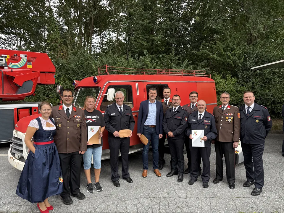 Eine Gruppe von Menschen steht vor einem roten Van.