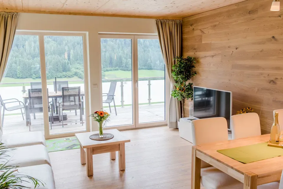 ein Wohnzimmer mit einem Tisch, Stühlen und einem Fernseher