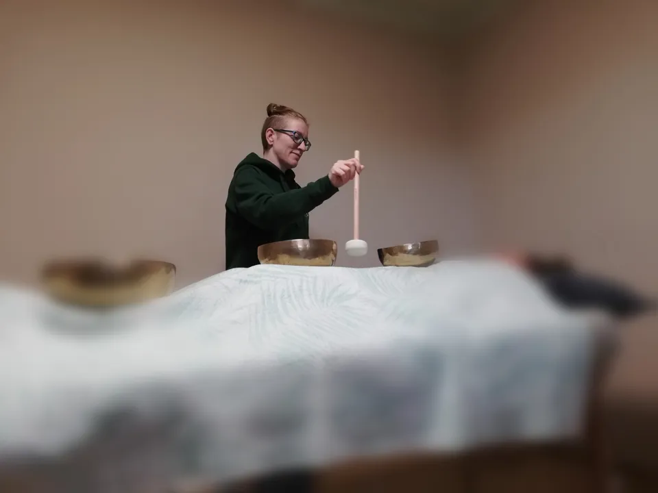 eine Person, die einen Stock über einem Tisch mit Schüsseln hält