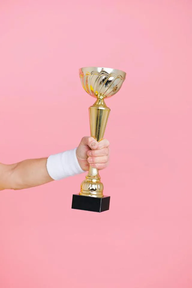 eine Person, die eine Trophäe hält