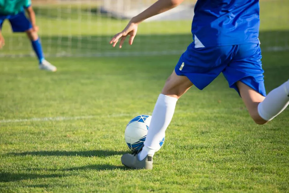 eine Person, die einen Fußball tritt