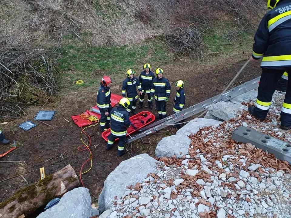 eine Gruppe von Feuerwehrleuten, die neben einer Leiter stehen