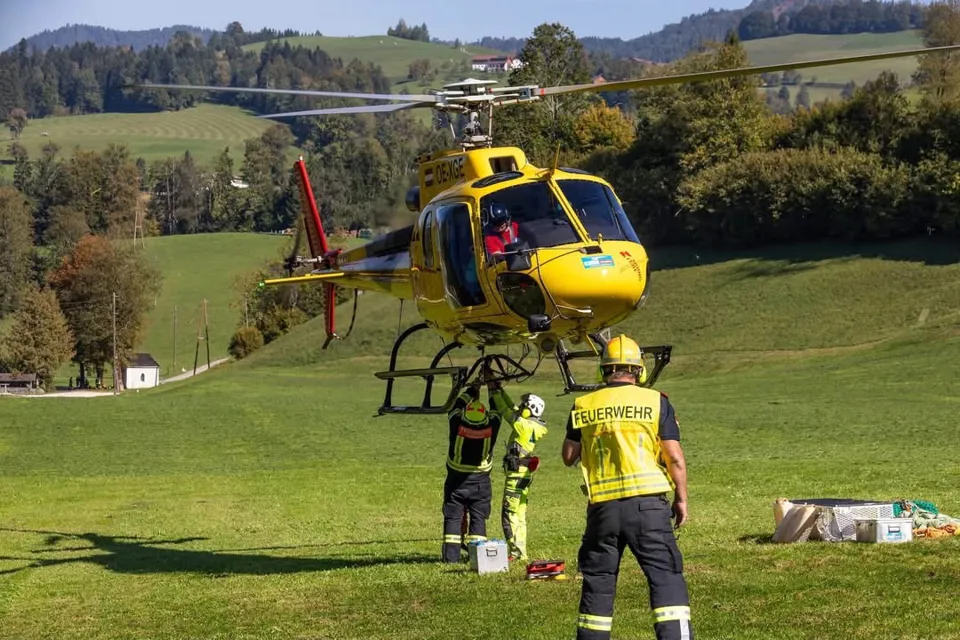 eine Gruppe von Menschen, die neben einem Hubschrauber stehen