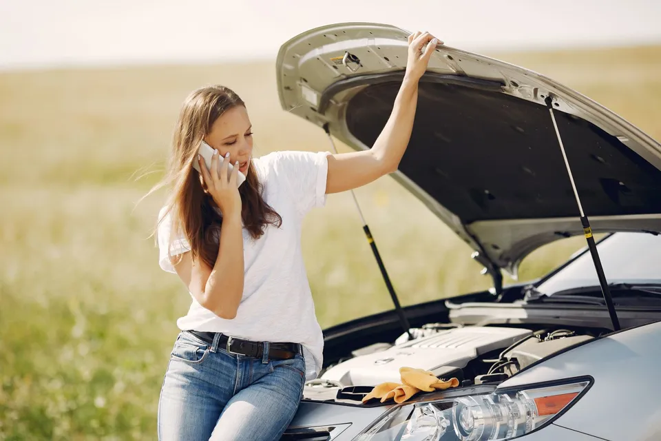 eine Person, die auf einem Auto steht und ihre Hände vor ihr Gesicht hält