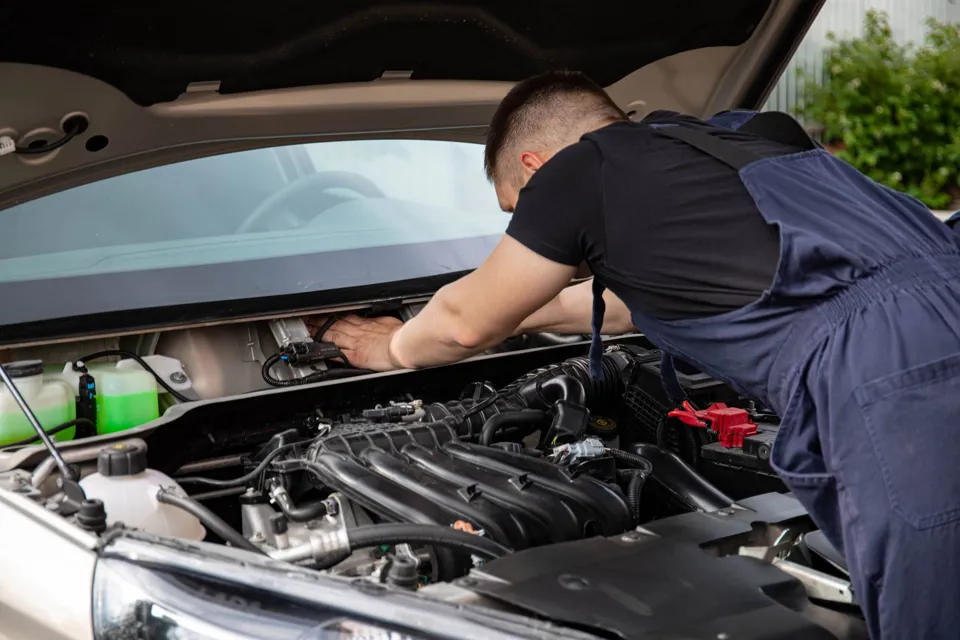 eine Person, die den Motor eines Autos betrachtet