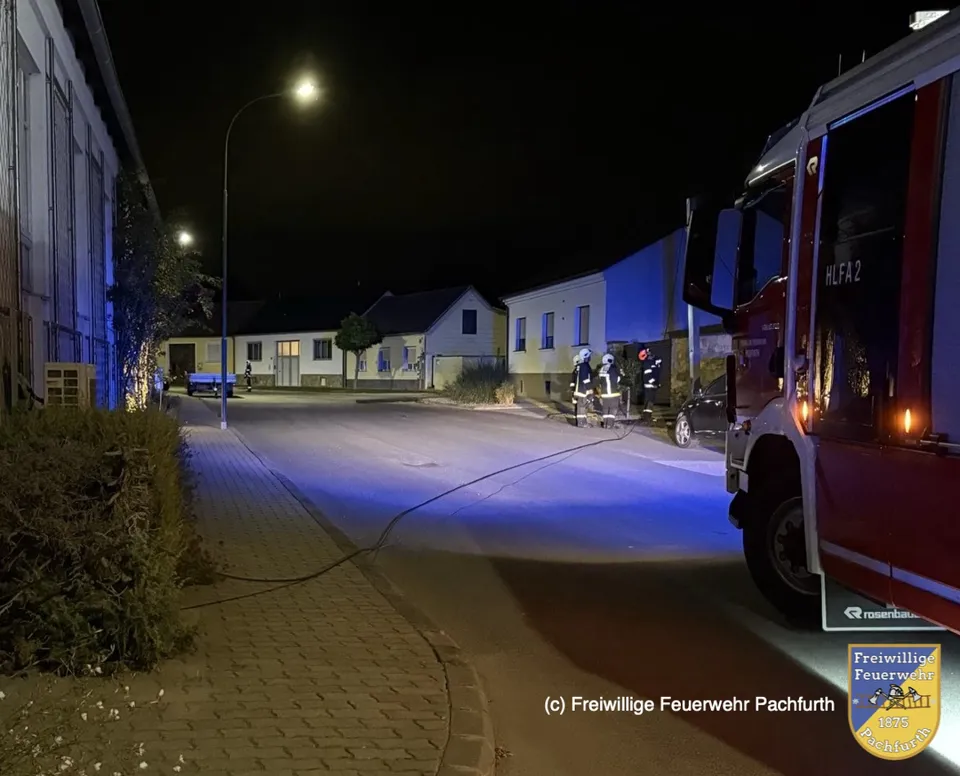Ein Feuerwehrauto auf einer Straße bei Nacht.