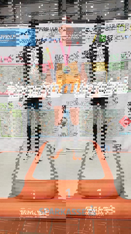 eine Person steht auf einer Matte und hält ein Schild hoch