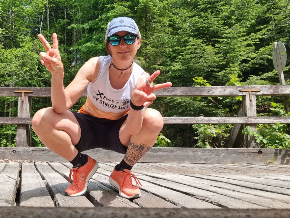 eine Person, die auf einer Holzbrücke hockt