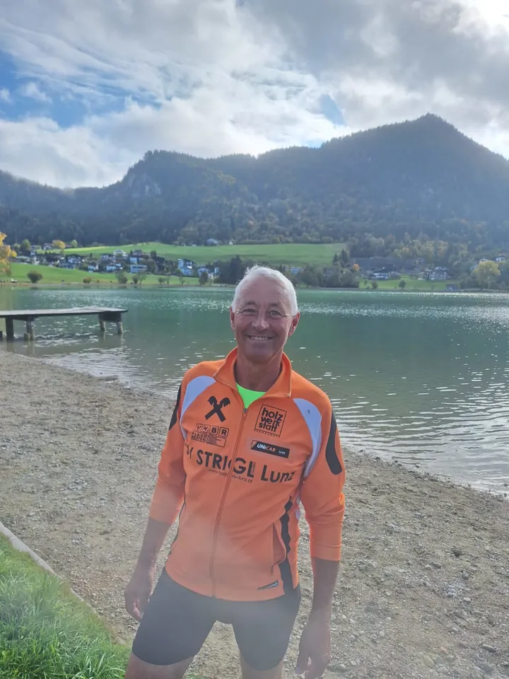 eine Person, die an einem See am Strand steht