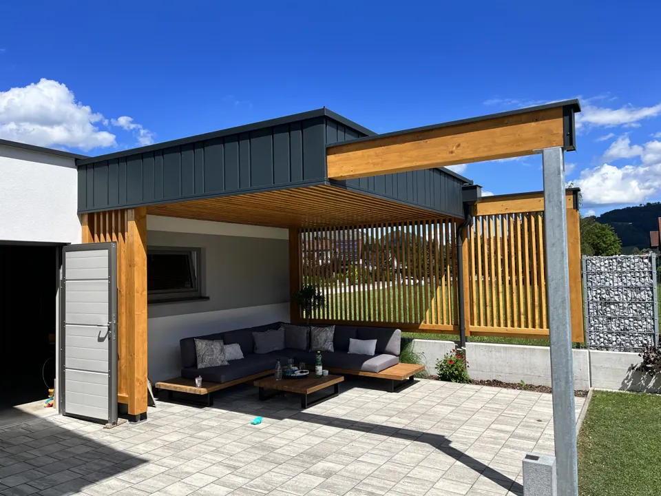 eine Terrasse mit einer Couch und einer Bank