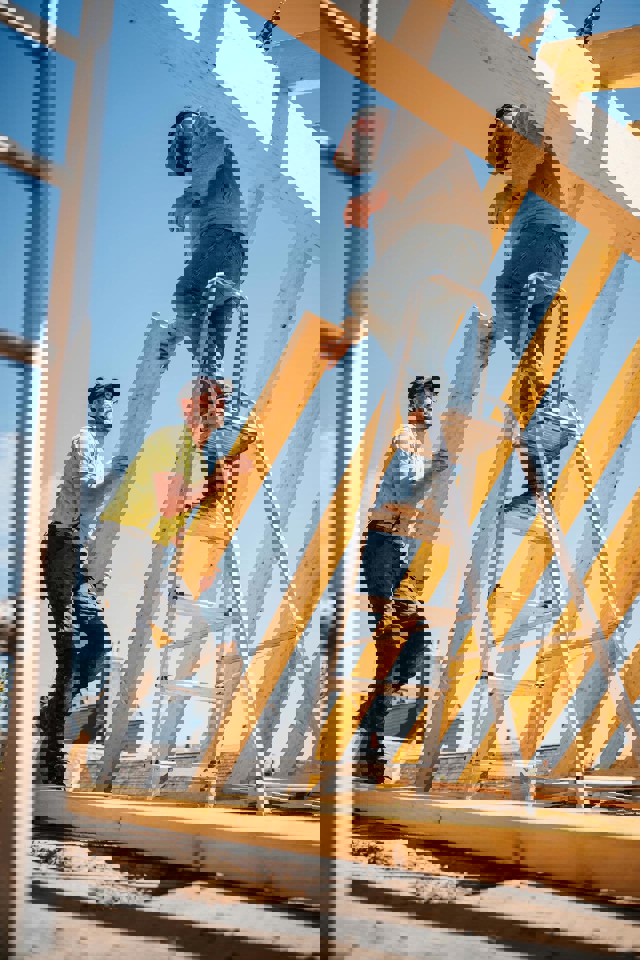 eine Person auf einer Leiter, die ein Stück Holz hält