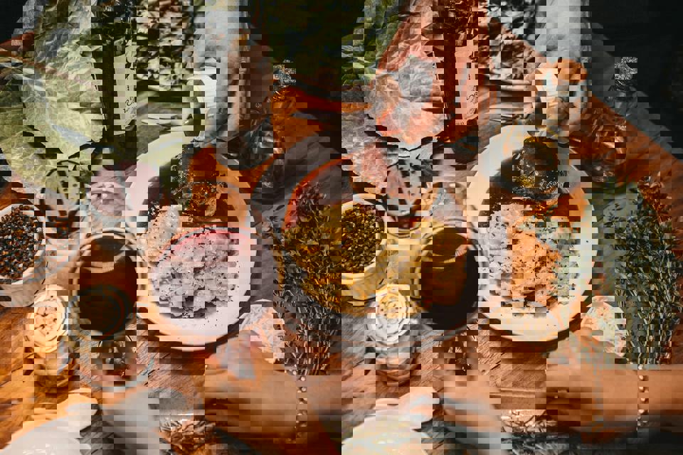 Eine Person gießt Sauce auf einen Teller mit Essen.