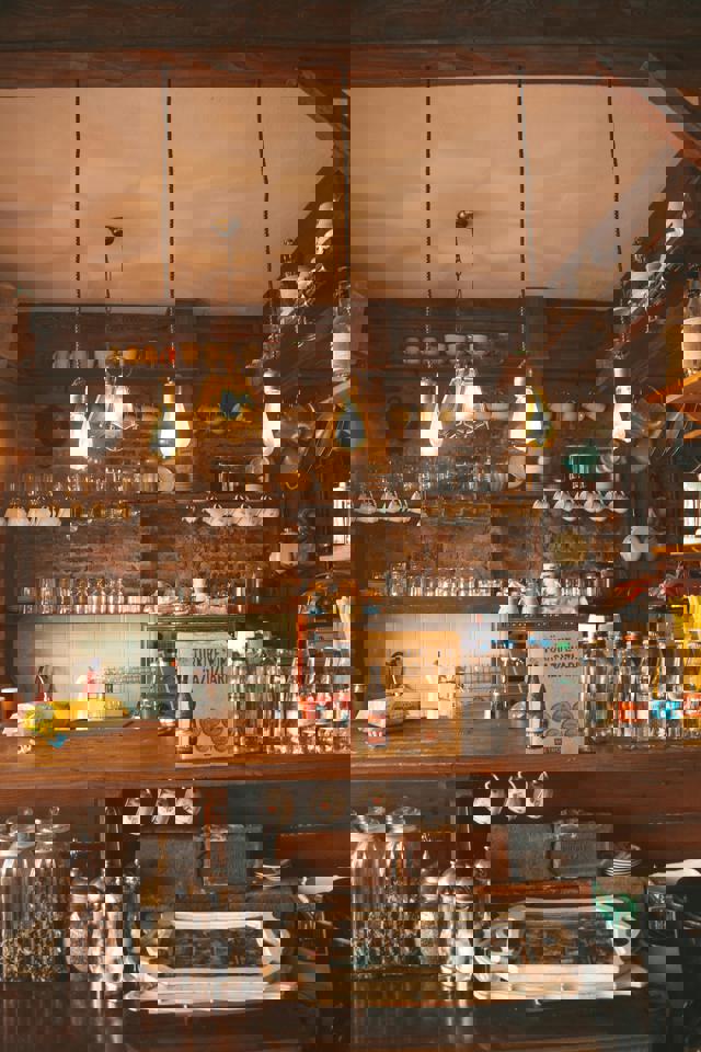 eine Küche mit einer Theke und Regalen mit Flaschen und Gläsern