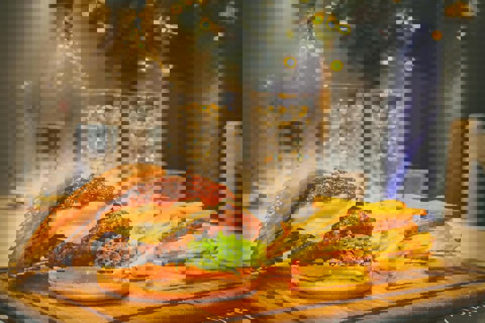 Ein Burger und Pommes auf einem Holzbrett.