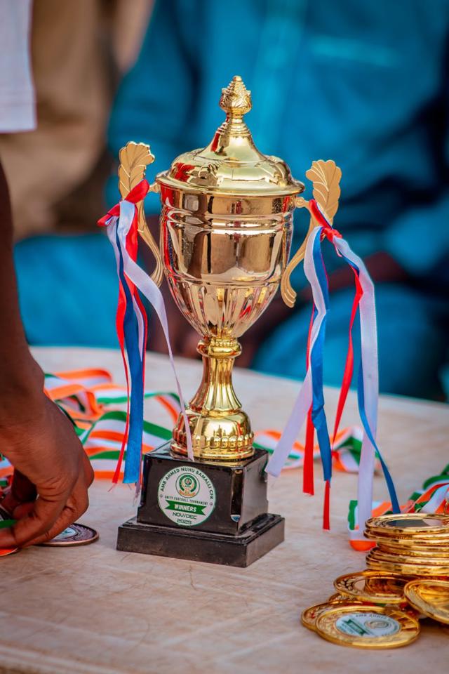 eine goldene Trophäe mit Bändern auf einem Tisch