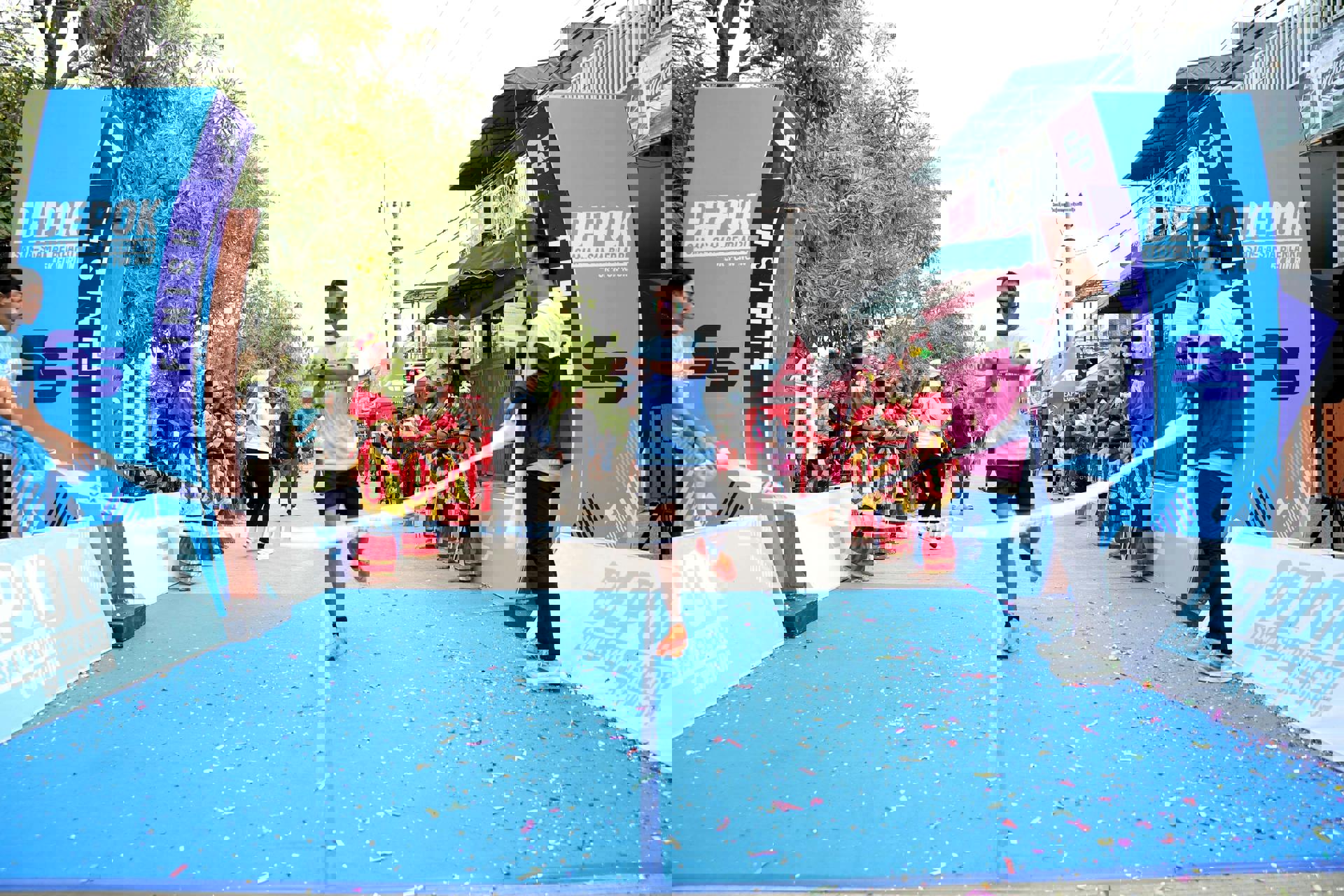 eine Person, die auf einer blauen Bahn mit einem weißen Band läuft