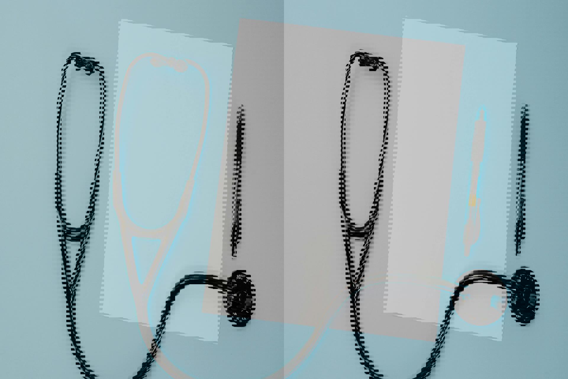 Ein Stethoskop und ein Stift auf blauem Hintergrund.