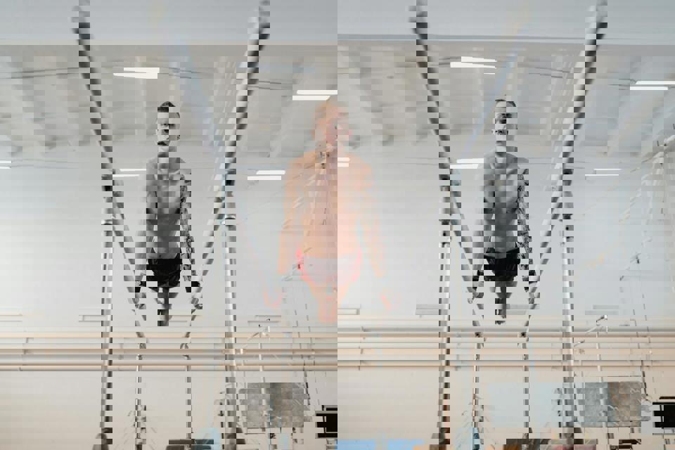 eine Person, die auf den Parallelbarren springt