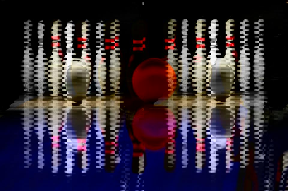 Eine Bowlingkugel vor Kegeln.