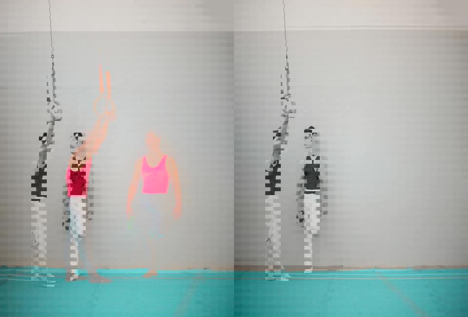 Eine Person hält einen Ring, auf dem eine andere Person steht.