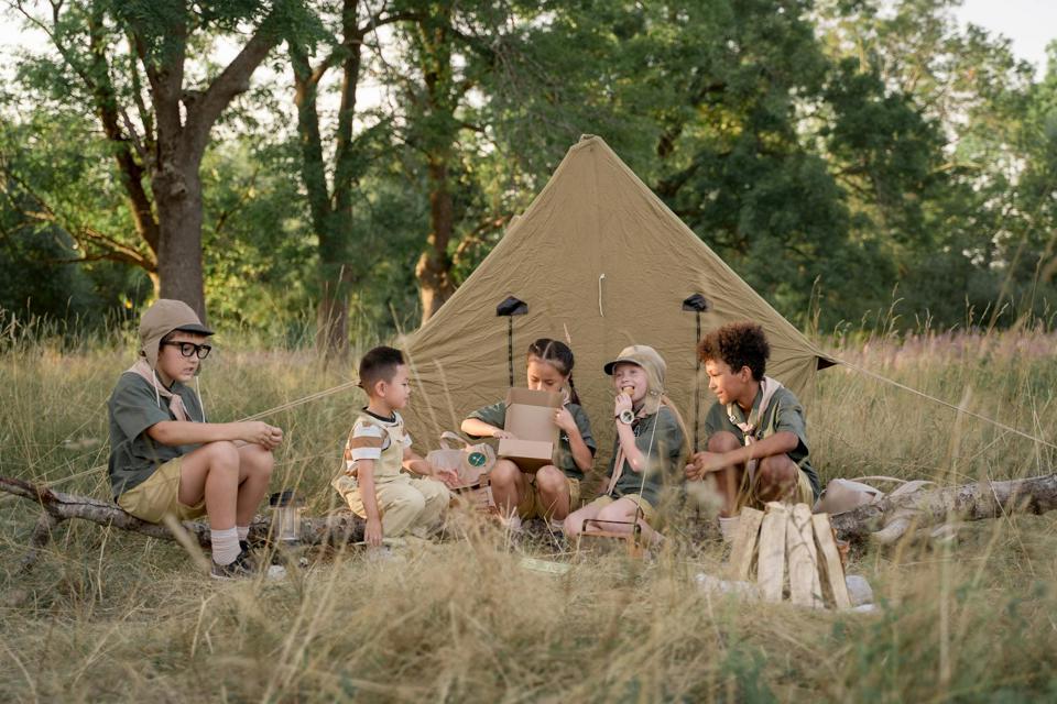 eine Gruppe von Kindern, die auf einer Wiese sitzen
